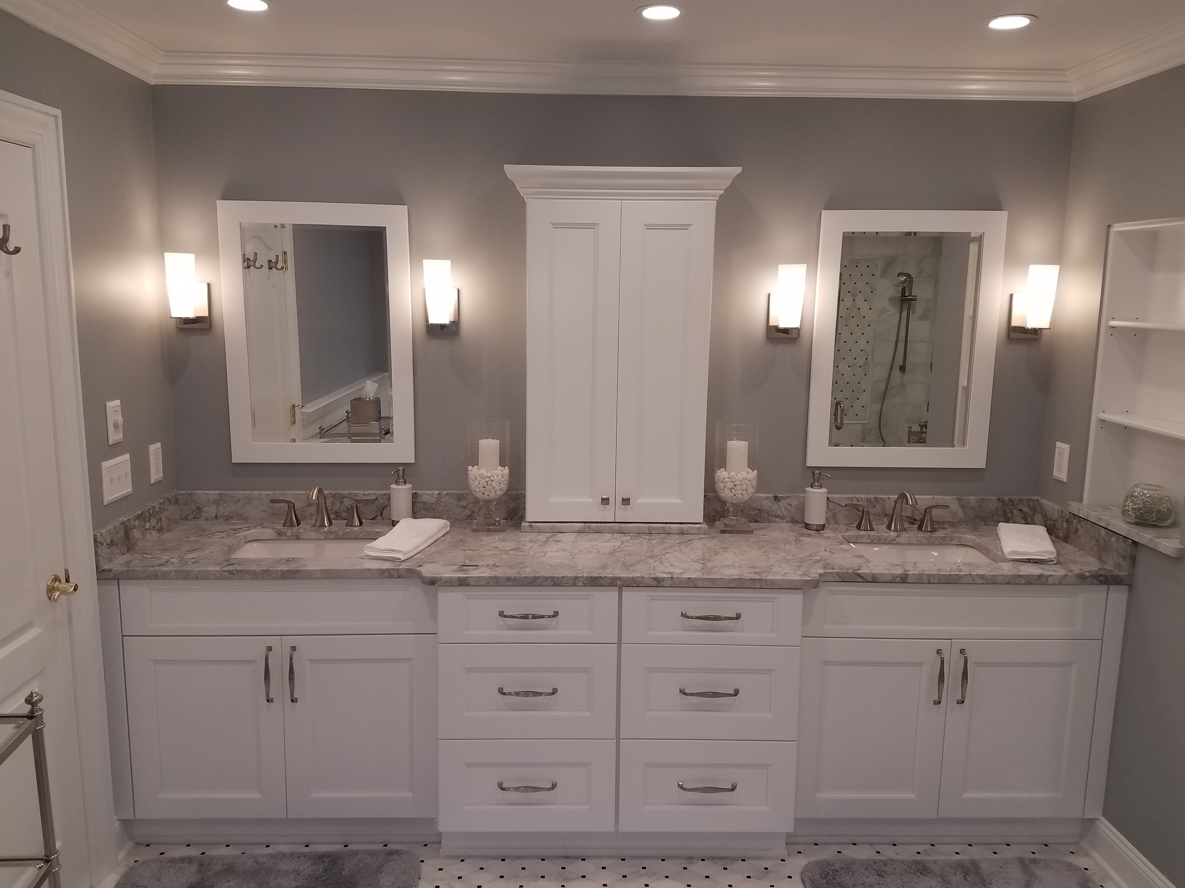 White shaker-style cabinets form a double vanity topped with a gray and white marble-look countertop, two undermount sinks, and brushed nickel faucets.