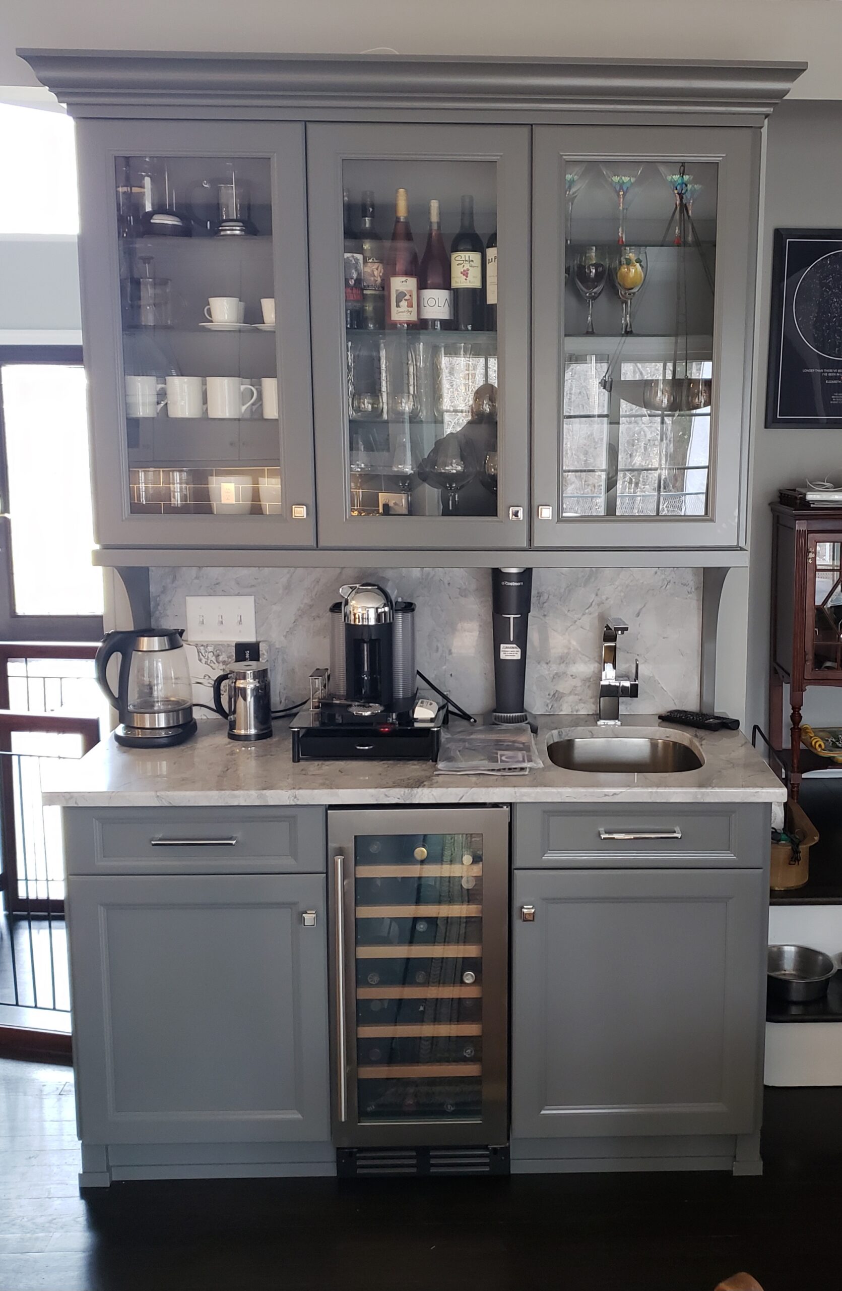 Home coffee and wine bar setup with glass-door cabinets