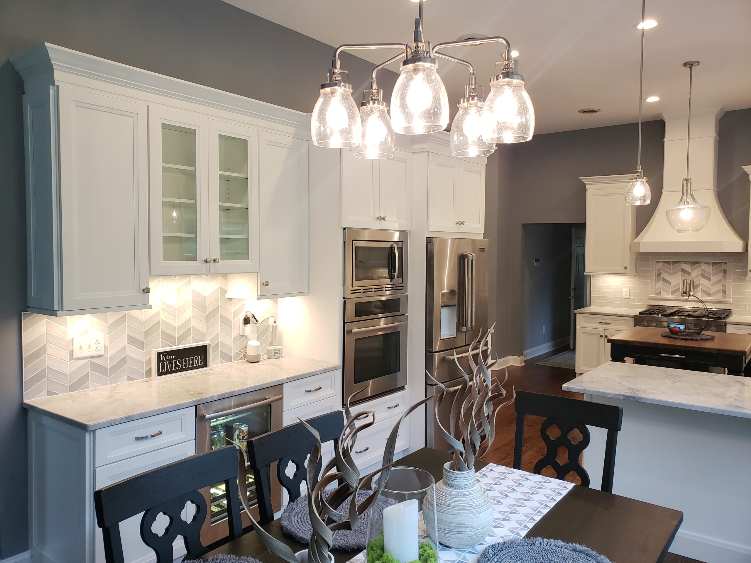 Spacious kitchen with white cabinetry and glass pendant lights