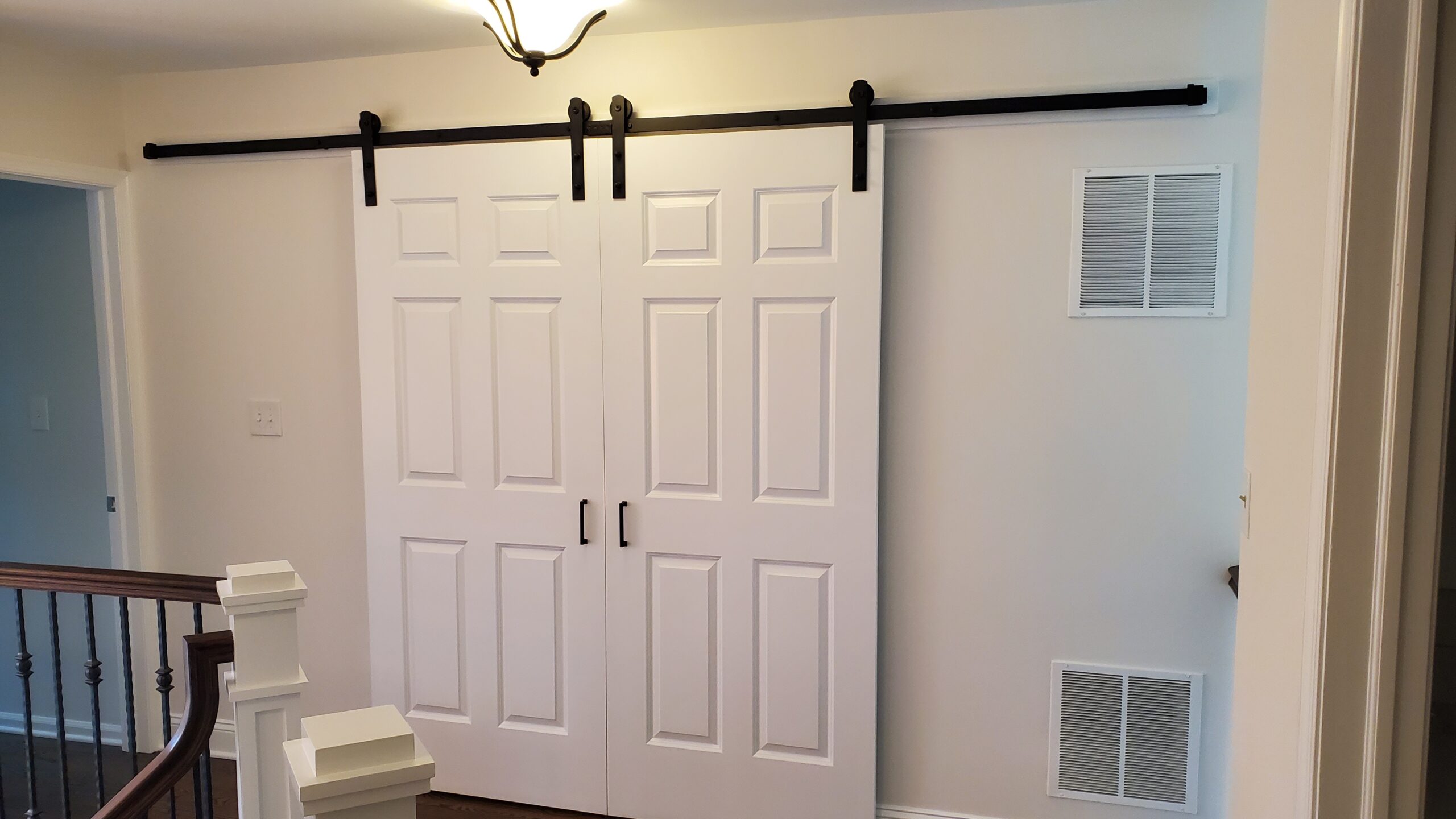 Sliding barn door with white panels inside modern home